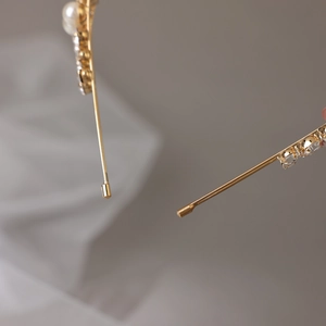 Detailed macro view of gold headband with white pearls and sparkling rhinestones