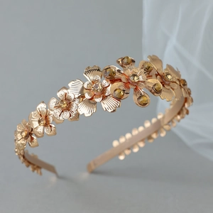 Detail of gold metal headband with intricate floral design and amber crystals for brides