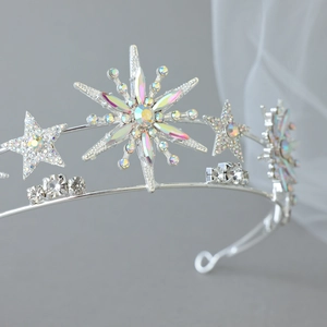 Close-up of silver bridal tiara with sparkling crystal stars and snowflake rhinestones