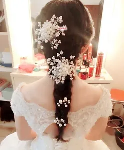 Detail of bridal hair comb with handmade pearls and crystals on elegant braid