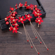 Detailed view of red silk flowers and golden tassels on Chinese bridal hair accessories