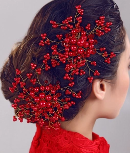 Detail of red handmade crystal pearls and gold wire floral bridal hair comb for weddings