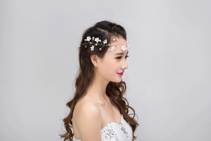 Détail d'un bandeau de mariée avec fleurs en dentelle, perles et perles de cristal