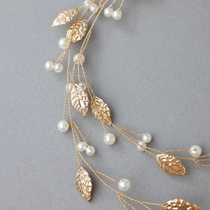 Macro detail of golden metal leaf wedding hair vine with round imitation pearls