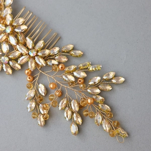 Detail of champagne crystal bridal hair comb with gold leaves and artificial pearls