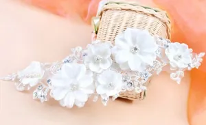 Detail of handmade bridal headpiece with lace flowers, shiny pearls and rhinestones