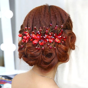 Detail of red crystal bridal hair piece with gold wire flowers and handmade beads