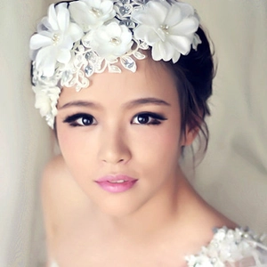 Close-up of white bridal headpiece featuring lace flowers, embroidery and sparkling crystals
