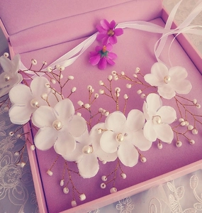 Detail of bridal floral headpiece with white silk flowers and pearls on golden wire
