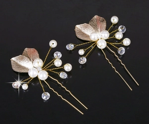 Detail von goldenen Blatt-Haarnadeln mit weißen Perlen und Kristallen für Brautfrisuren