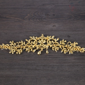 Détail d'un bijou de tête de mariée doré vintage avec feuilles évidées et pendentifs