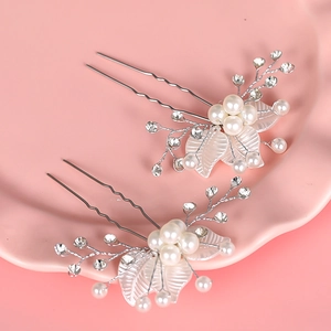 Vue détaillée de deux épingles à cheveux de mariée avec perles blanches, cristaux et feuilles