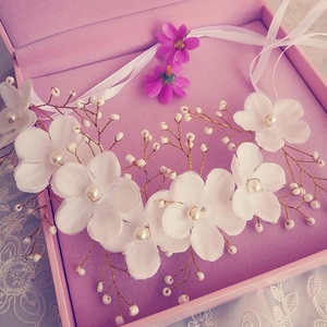 Handmade bridal hairpiece with white fabric flowers, pearls, and gold wire for wedding