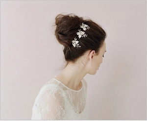 Detailed view of silver leaf hair pins with pearls and rhinestones on a bridal updo