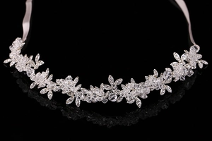 Close-up of bridal crystal headband with silver flower leaf design and ribbon ties
