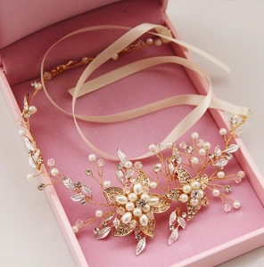 Détails d'un bandeau de mariée avec perles et strass posé sur une boîte cadeau rose