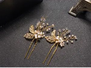 Detailed close-up of golden leaf hair pins with white pearls and crystal rhinestones