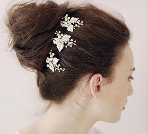 Detailed close-up of a 3-piece set of bridal leaf hair pins with pearls and rhinestones