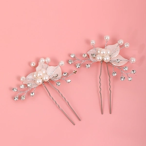 Détail d'épingles à cheveux de mariée avec perles blanches, cristaux et feuilles roses