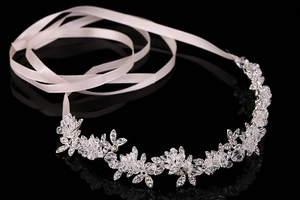 Detail of silver floral bridal headband with crystals and white satin ribbons