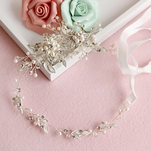 Détails d'un serre-tête de mariée argenté orné de perles, strass et ruban en soie doux