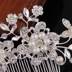 Detail of silver bridal hair comb with elegant faux pearls and shimmering rhinestones