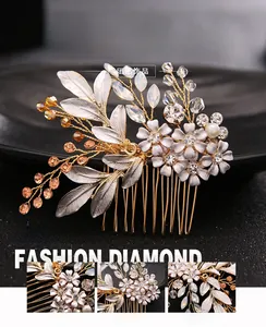 Detailed close-up of bridal hair comb featuring golden leaves, white flowers and crystal beads