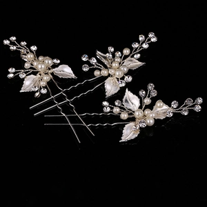 Detail view of three handmade silver leaf hair pins with pearls and crystals for weddings