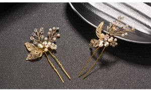 Macro detail of bridal hair pins featuring gold leaves, white pearls and clear crystals