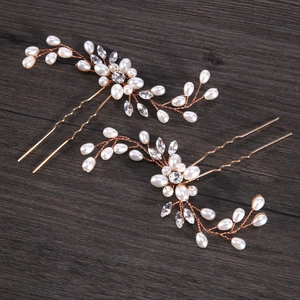 Détail des épingles à cheveux de mariée en or rose avec perles blanches et cristaux
