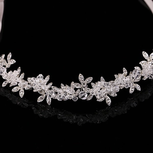 Elegant silver bridal tiara with sparkling crystals and leaves on black mirror