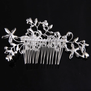 Detailed view of silver hollow floral hair comb with metallic vine pattern and polished teeth
