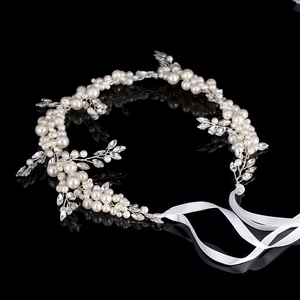 Macro shot of bridal hairband with white pearls, crystals and silver wire craftsmanship