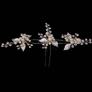 Detail of silver leaf bridal hair pins with white pearls and sparkling rhinestones
