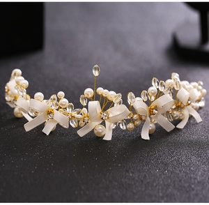 Detailed macro view of white silk bows with faux pearls and crystals on bridal headband