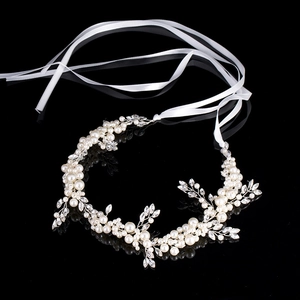 Detailed macro view of handmade bridal hairband with white pearls and crystals