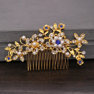 Close-up of golden bridal hair comb with blue gemstones, pearls and crystals