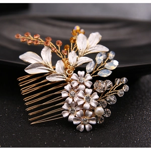 Macro detail of bridal hair comb with silver flowers, crystals, and amber beads