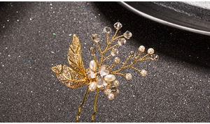 Detail of handmade gold leaf hair pin with white pearls and sparkling crystals