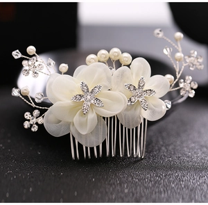 Detail of bridal hair comb with white chiffon flowers, pearls, and rhinestones