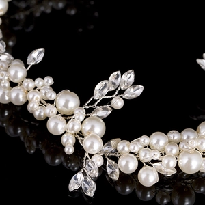 Macro detail of bridal headband featuring white pearls and marquise rhinestones on silver wire