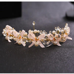 Detailed macro of handmade bridal headband with pink ribbon, pearls, and crystals