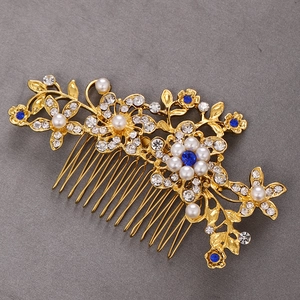 Detailed view of bridal hair comb with blue crystals, pearls, and gold floral accents