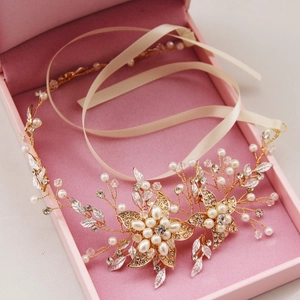 Bandeau de mariée avec perles et cristaux dorés présenté sur un coffret cadeau rose