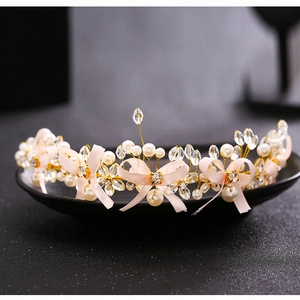 Detail of bridal headband with white pearls, crystals and pink grosgrain bows
