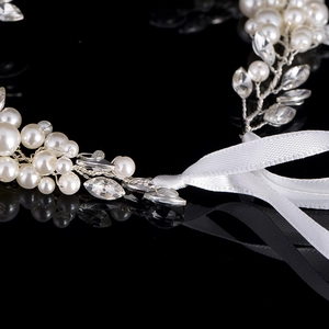 Macro detail of handmade bridal headband with white pearls and crystals on silver wire