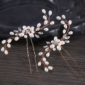 Détail d'épingles à cheveux de mariée avec branches dorées, perles et strass brillants