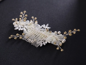 Détail d'un peigne à cheveux mariée avec fleurs en tissu, perles et cristaux ambrés