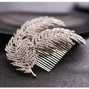 Macro shot of silver bridal hair comb with sparkling rhinestones and crystal leaf detail