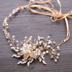 Serre-tête de mariée européen avec perles, strass et fleurs sur un fond de bois brun